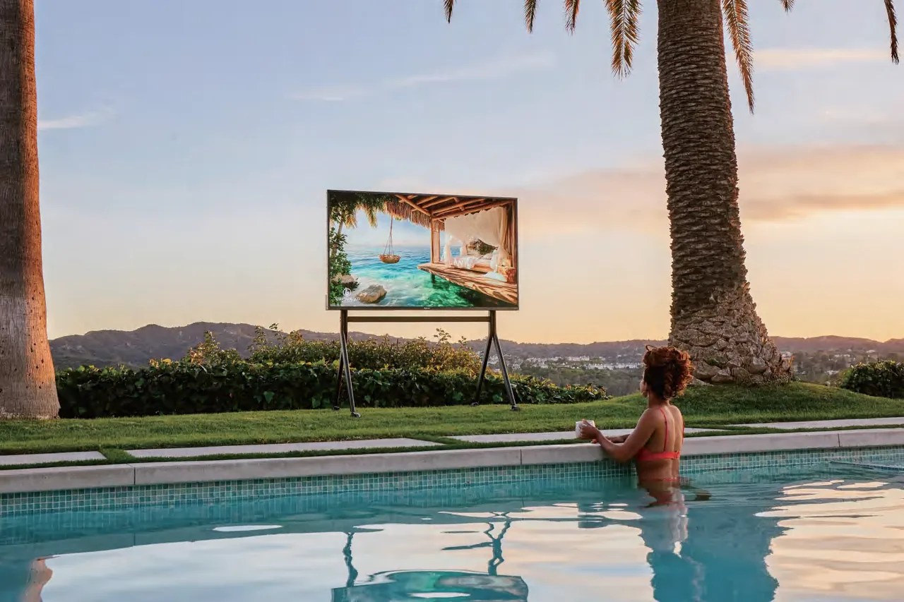 Sylvox outdoor television on a stand beside a pool at sunset