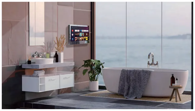 Sylvox Mirror TV mounted on a bathroom wall beside a freestanding bath, screen active